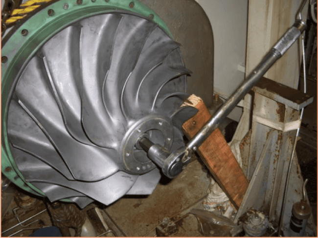 Technician tightening the locknut during a turbo impeller repair using a precision torque wrench